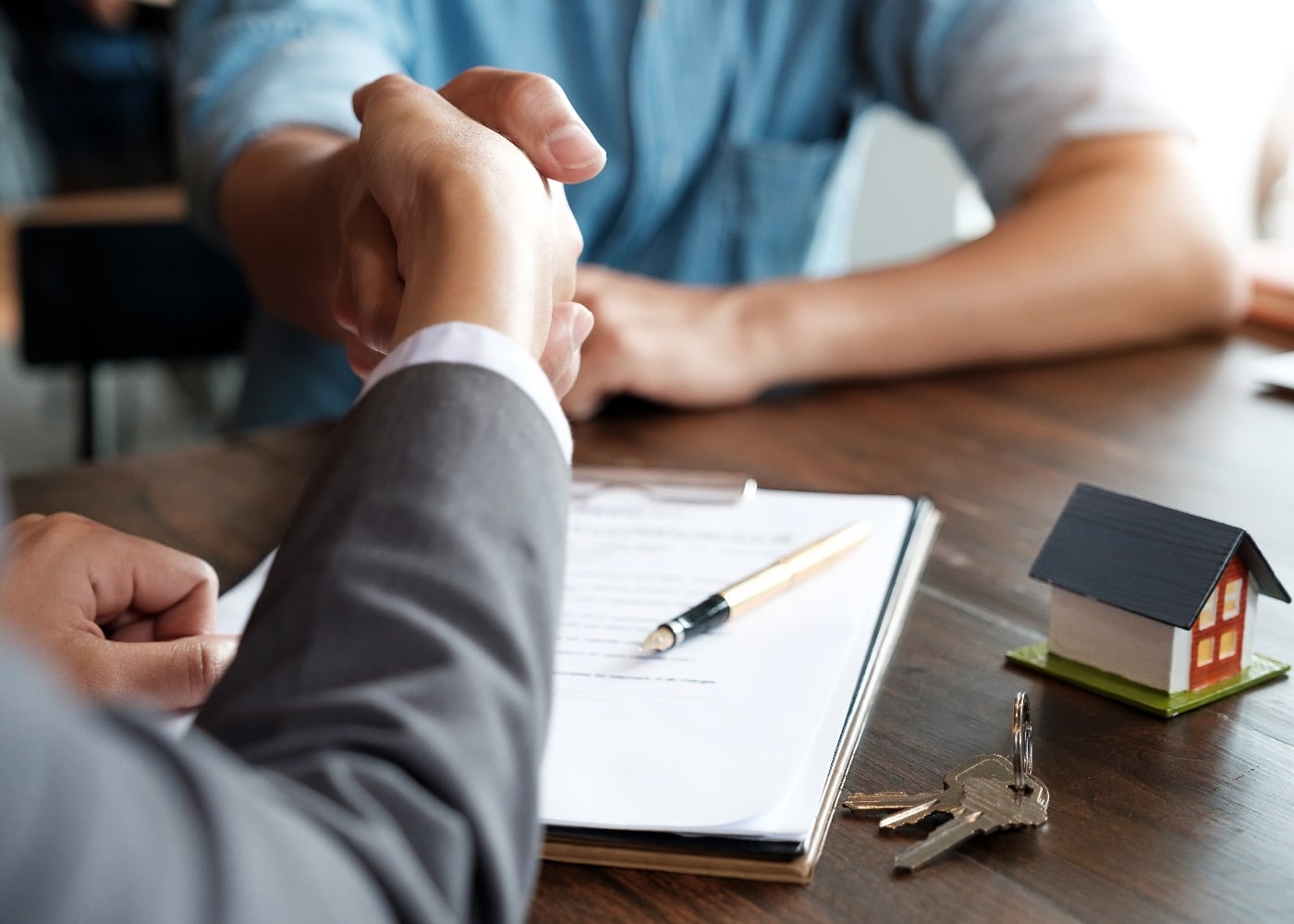 Estate agent shaking hands with his customer after contract signature