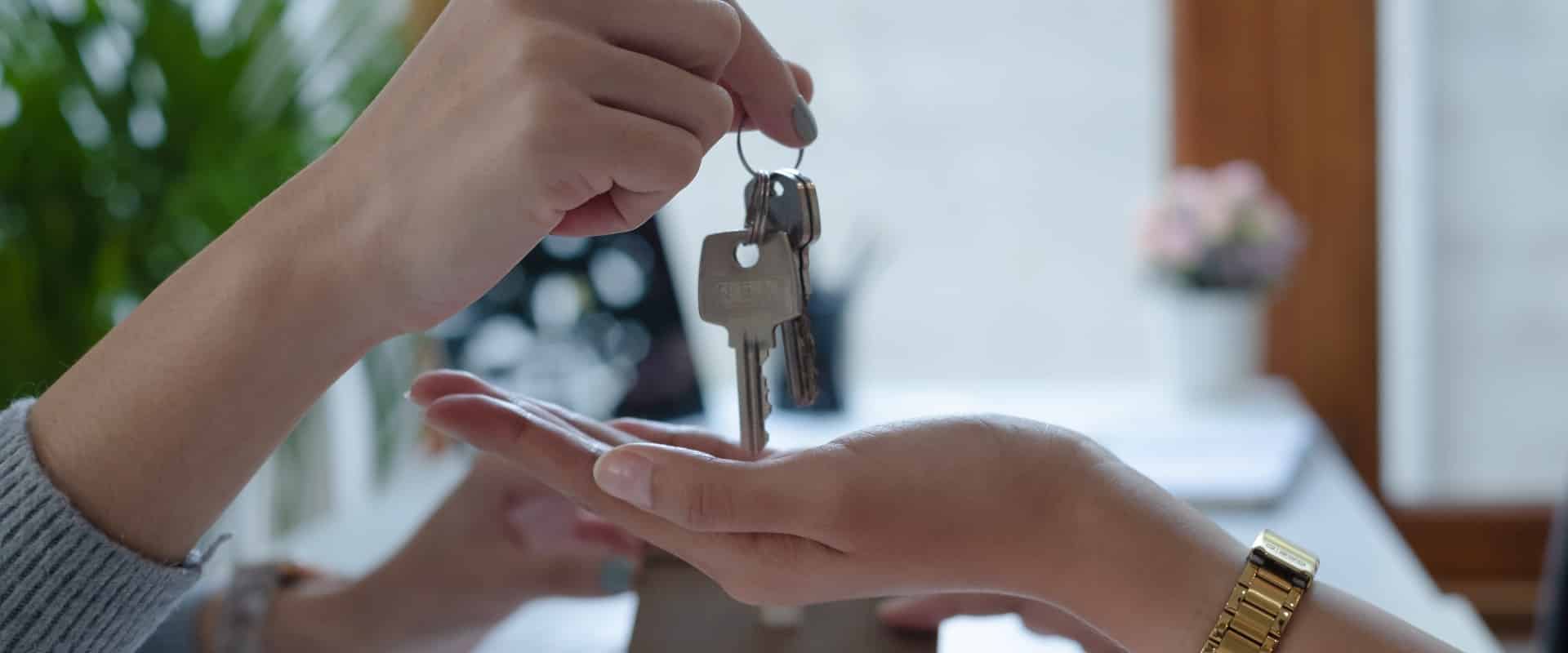 Partial view of businesswoman showing house model and keys