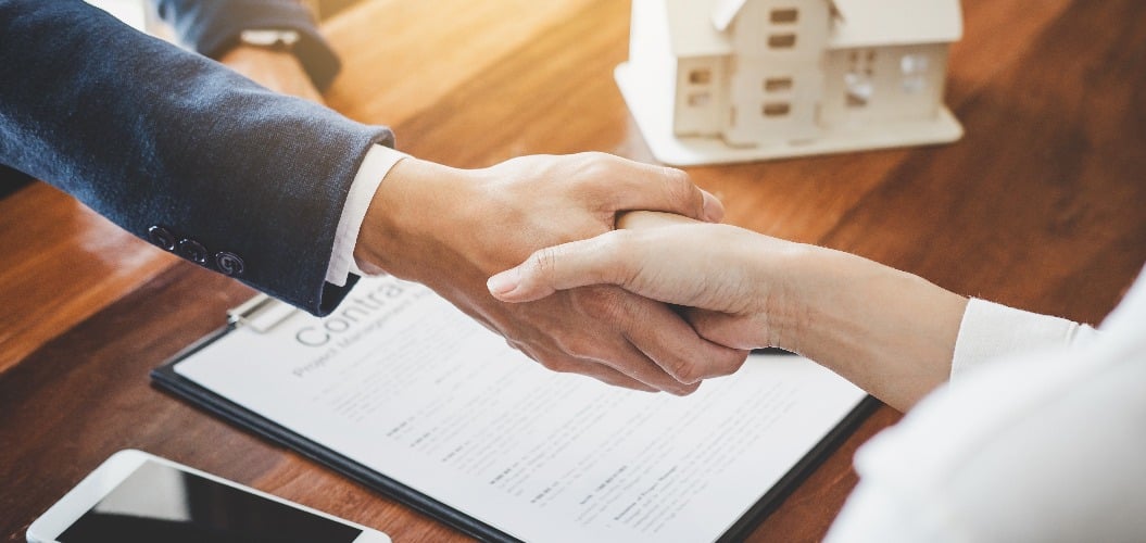 Real estate agent and customers shaking hands together celebrating finished contract after about home insurance and investment loan, handshake and successful deal