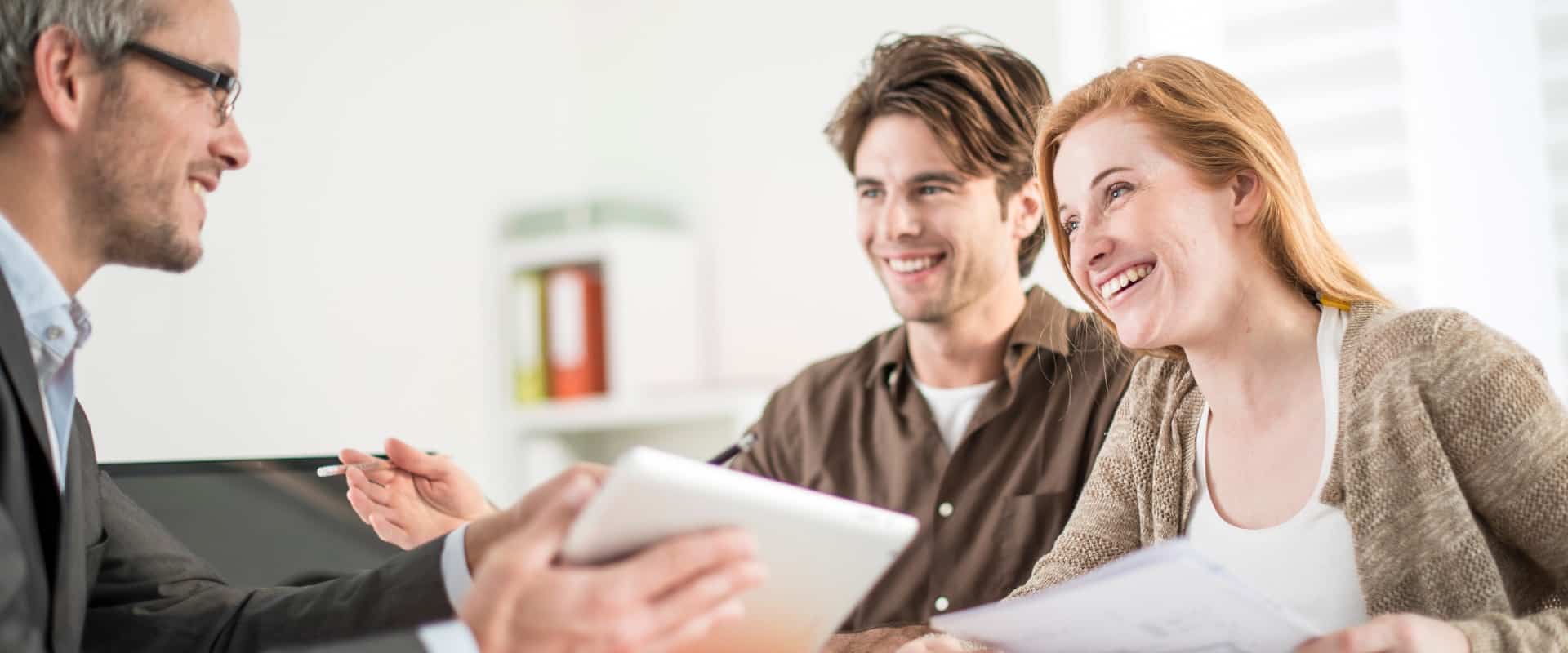 real-estate agent shows a build project on a digital tablet to a